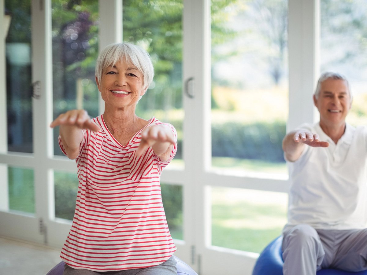 Older couple practicing chair yoga